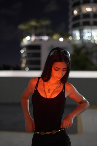Miami lifestyle portrait of a woman in black tank top and gold jewelry at night by Frank