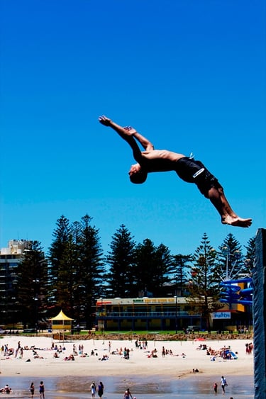 A person diving off the Glenelg Jetty