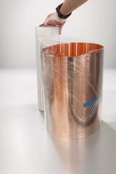 Copper sheet being covered with plastic wrap before shipment