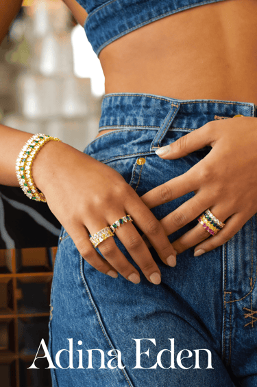 Adina Eden - a woman shows off beautiful bracelets and rings, while wearing a blue top and jeans 