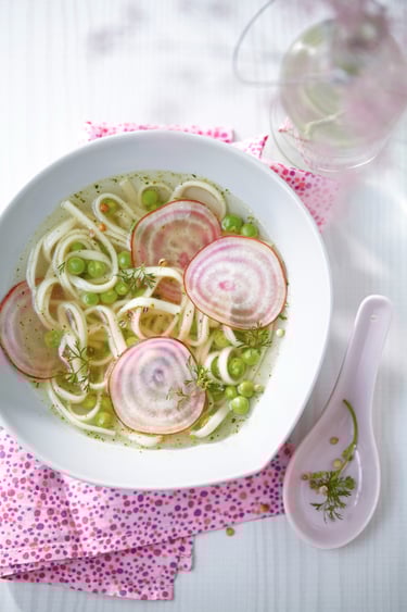 a bowl of soup with radishes and peas
