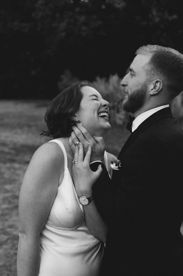 candid black and white photo of a bride and groom laughing