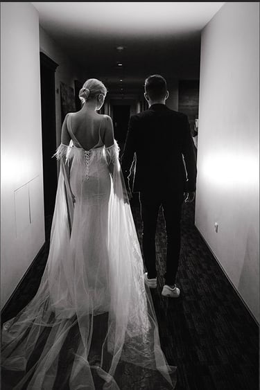 a bride and groom walking down a hallway