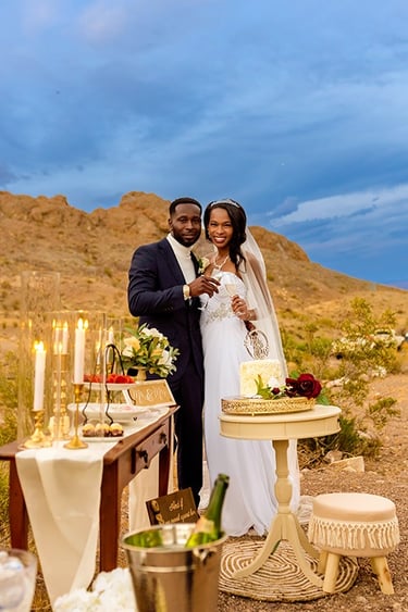 a man and woman standing in front of a desert