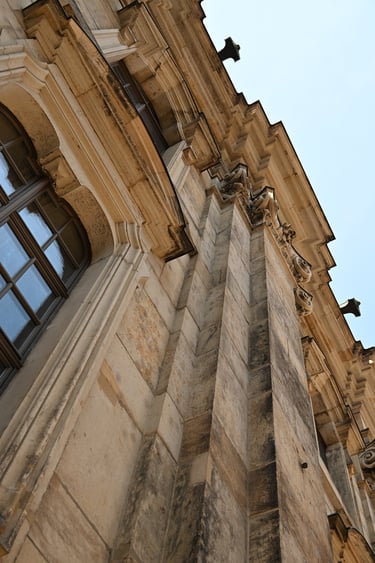 Low angle view of historic Baroque sandstone architecture with ornate facade details and arched windows.