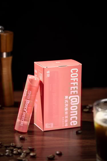 a pink box of coffee and a cup of coffee