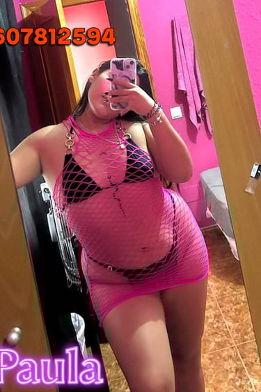 a woman in a pink dress is taking a selfie