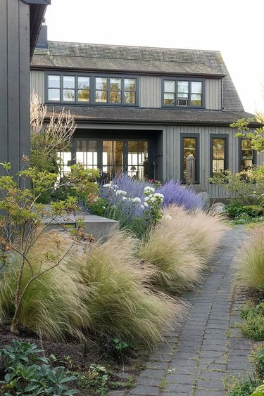 Garden path with ornamental grasses, soft planting and a modern house, showing a mature landscape sh