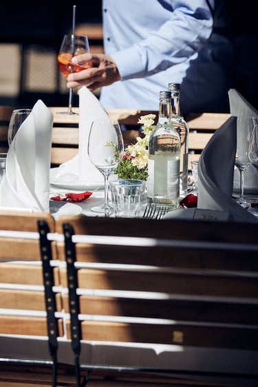 A wedding guest walking past a table holding an Aperol Spritz.