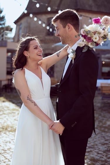 Brida and groom holding hands and laughing.