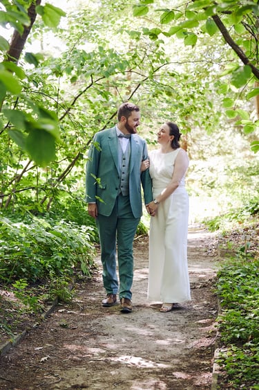 Bride and groom walking on a path in the botanical gardens.