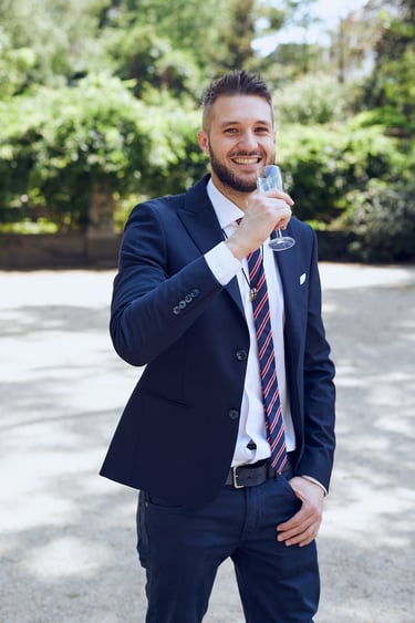 Ein lächelnder Bräutigam trinkt ein Glas Sekt.