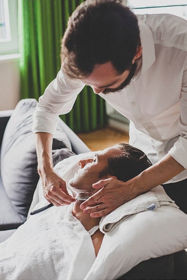 Der Bräutigam entspannt sich und lässt sich vor der Zeremonie rasieren.