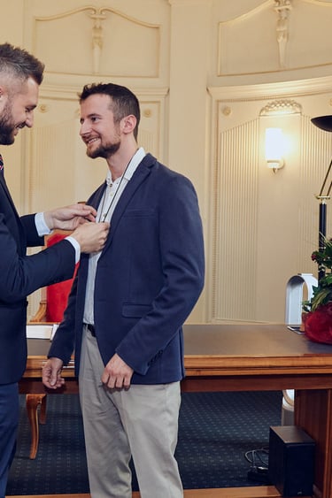 Der Bräutigam legt eine Hochzeitskette mit einem Band um den Hals seines Mannes.