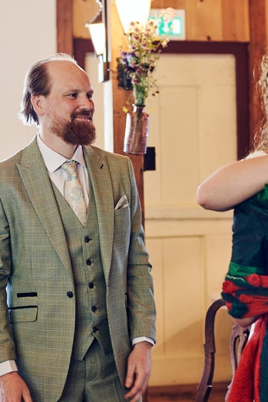 Der Bräutigam schaut auf seine Schwiegermutter, die die Braut umarmt.