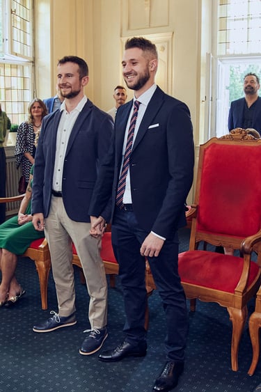 Zwei Bräutigame stehen während einer standesamtlichen Trauung auf.