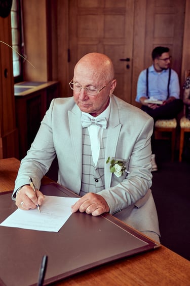 Unterzeichnung der Heiratsurkunde durch den Bräutigam.