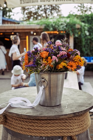 Bridal bouquets in a bucket on a table.
