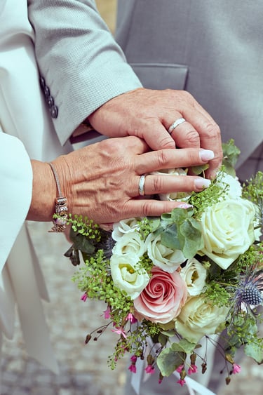 Close-up of bride's and groom's hands with wedding rings.