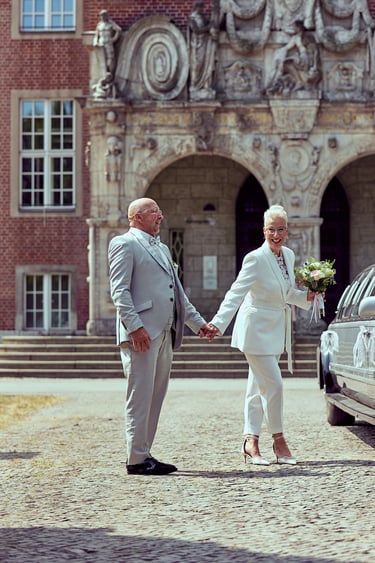 Bride and groom laughing in front of a the Reinickendorf town hall.