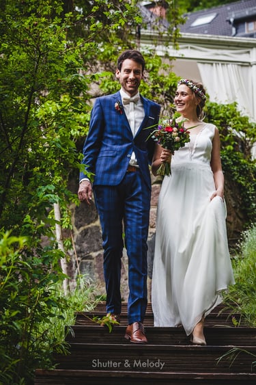 Bride and groom walking down stairs outdoors..