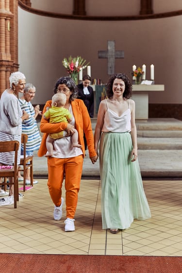Two brides walking on the church aisle after the wedding ceremony.