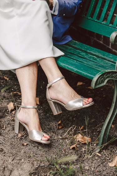 Nahaufnahme der silbernen Pumps der Braut.