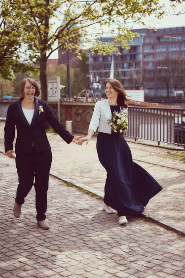 Ein frisch verheiratetes lesbisches Paar geht spazieren und hält sich an den Händen.