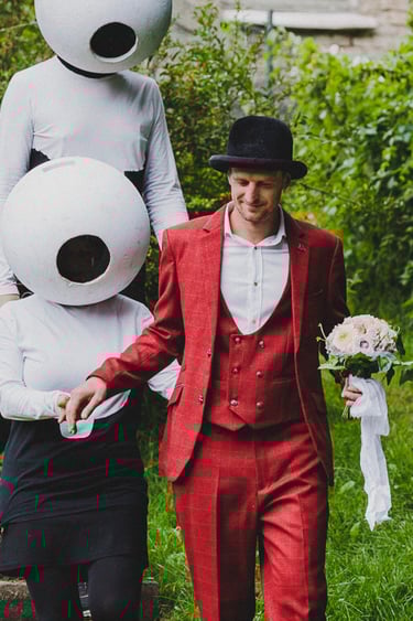 Groom being escorted by two people dressed as aliens.