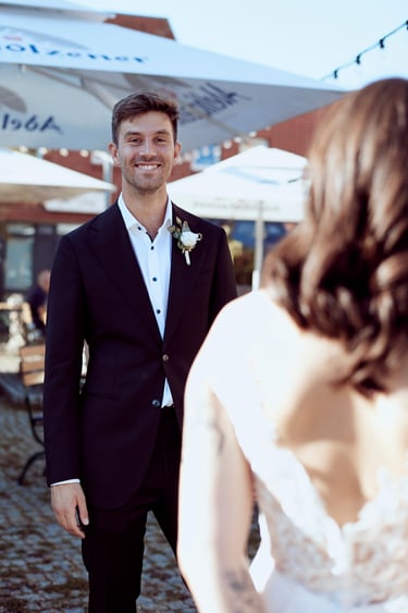 Happy groom looking over bride's shoulder.