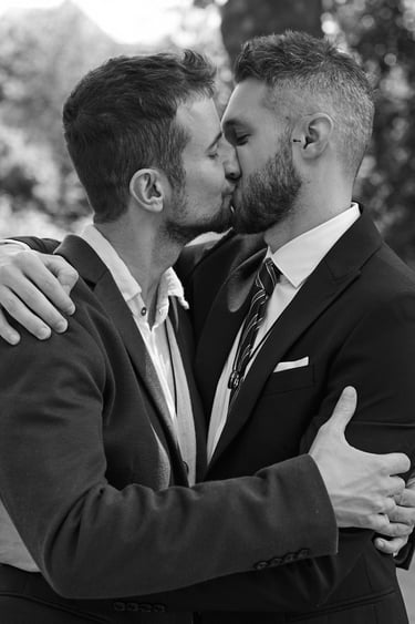 Grooms kissing while hugging each other.
