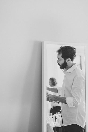 A male hairdresser reflected in a mirror.