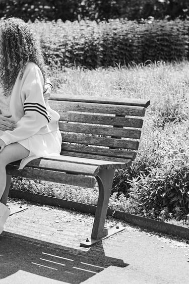 Ein junges Paar sitzt auf einer Bank in einem Park.