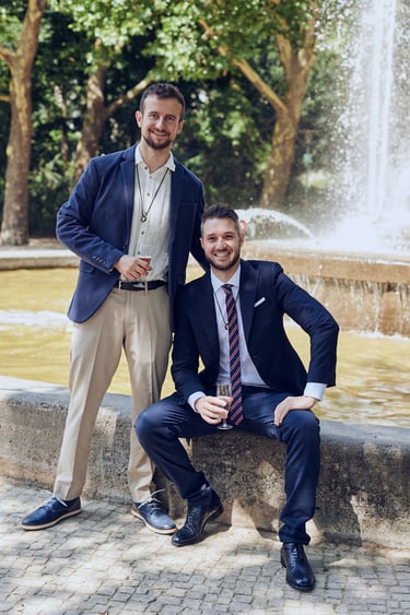 A portrait of two newlywed husbands in front of a fountain in Rudolph-Wilde-Park.
