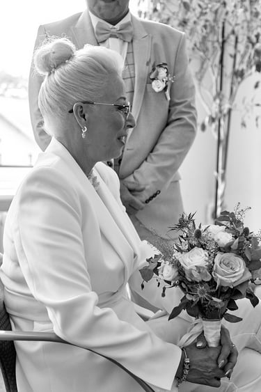 Eine reife Braut sitzt mit Blumen.