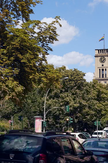 Turm des Standesamtes Tempelhof-Schöneberg über einer Baumreihe.