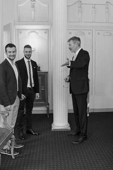 Ein Standesbeamter zeigt einem jungen schwulen Paar die Sitze.