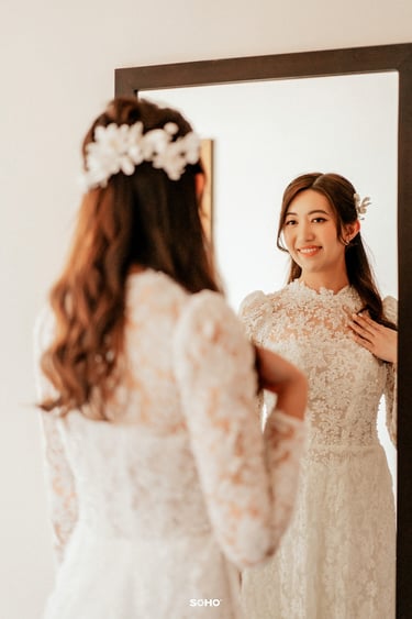 a woman in a wedding dress is looking at herself in the mirror