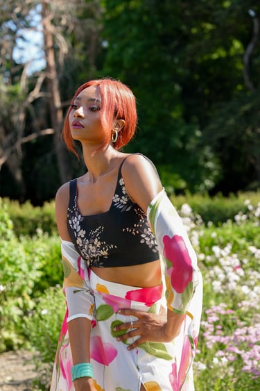 a woman model in a floral print dress and a black top
