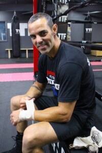 Paul sitting ringside wrapping hands as he prepares for sparring