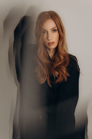a woman with long red hair and a black top