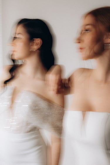 two women in white dresses standing next to each other