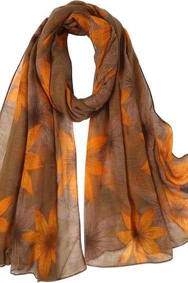 Lightweight floral leaf print fall scarf in brown-yellow tones, styled as a shawl or wrap.