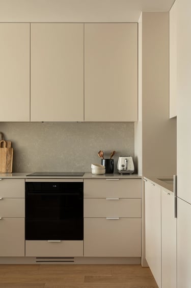 Fotografia wnętrz: beżowa kuchnia z kamiennym blatem, minimalizm. Profesjonalna sesja zdjęciowa.