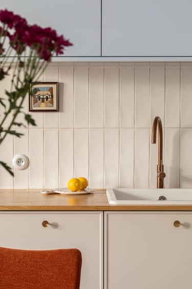 Detal w fotografii wnętrz: miedziana bateria i płytki.