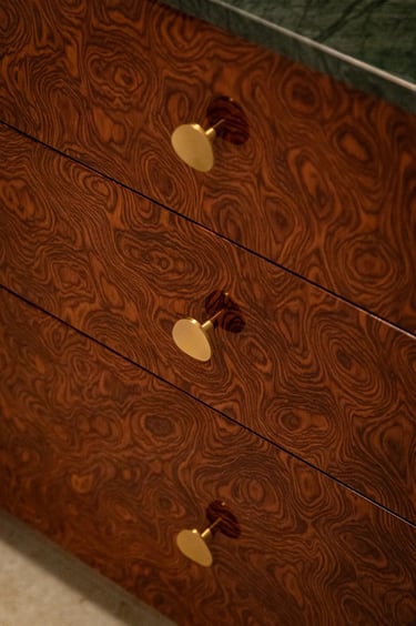 Fotografia mebli: detale forniru czeczota i złote gałki.