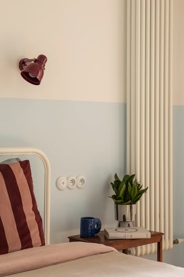 Stylizacja wnętrza: stolik vintage i błękitna lamperia w sypialni.