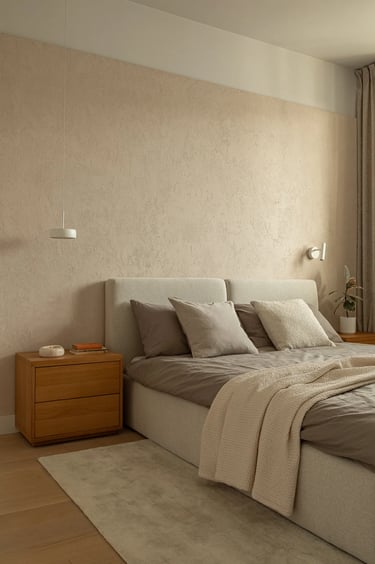 Sypialnia wabi-sabi z beżowym łóżkiem, tynkiem strukturalnym i drewnem.