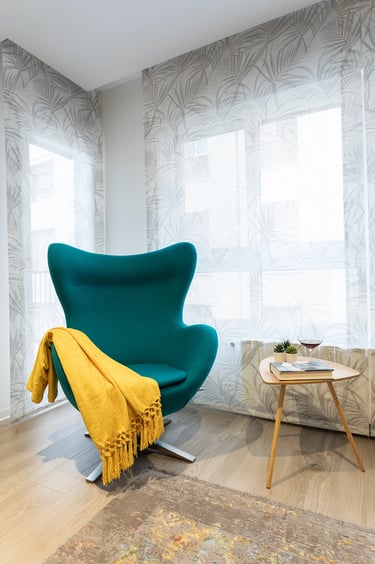 Butaca para rincón de lectura, junto a mesita auxiliar y decoración varia, IMPATTO interiorismo