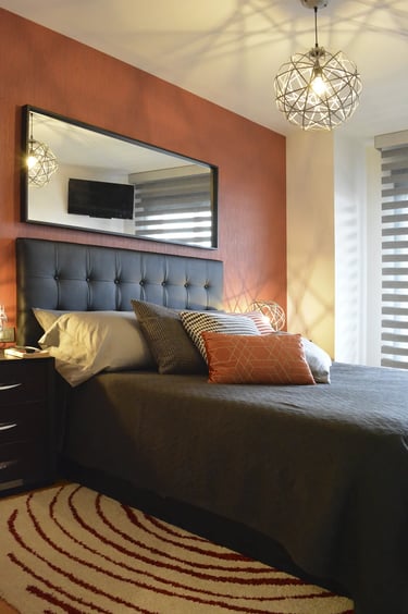 Proyecto de interiorismo de una habitación matrimonial con papel pintado rojo en cabecera y decoración a juego